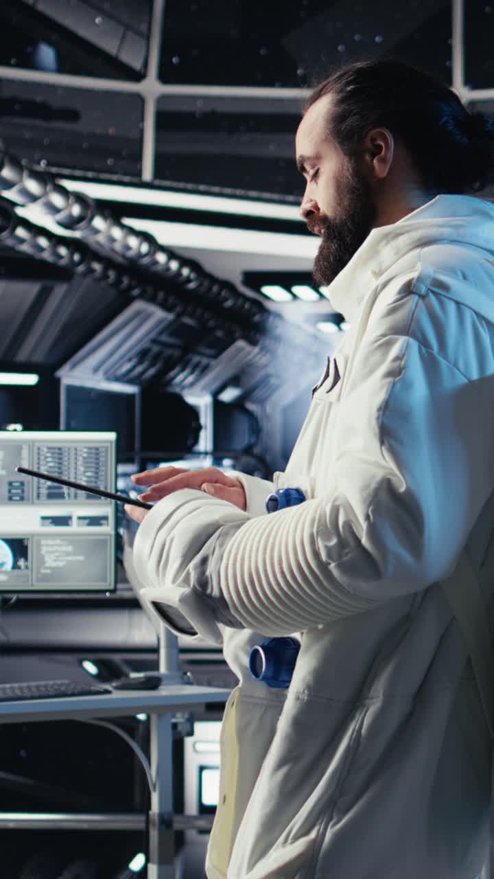 Vertical video Astronaut reading mission plan on tablet before stepping out of space station