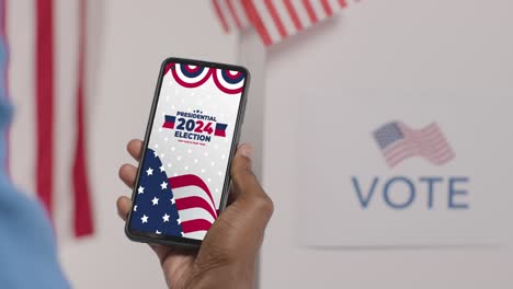 cerca de la mano sosteniendo un teléfono móvil con pantalla alentando a la gente a votar en las elecciones presidenciales de estados unidos de 2024 1