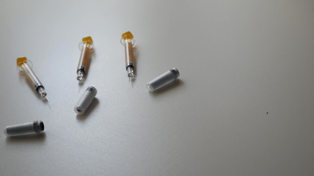 Pan shot of syringes and containers on flat surface