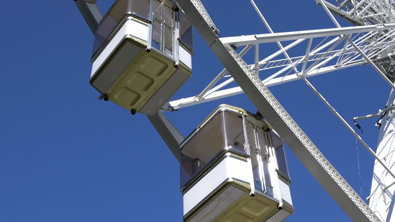 4K. Cabins of ferris wheel or big wheel that is spinning. Amusement park