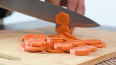 close-up of woman's hand cutting a carrot
