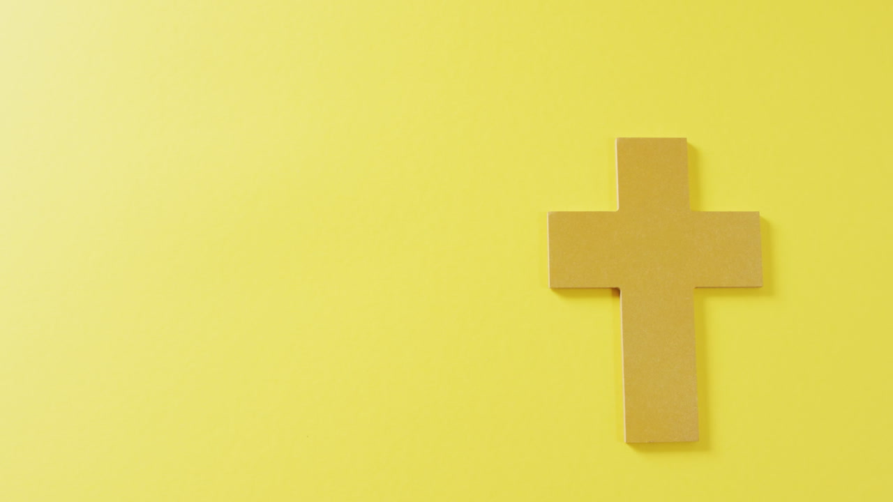 Video de símbolo de crucifijo cristiano marrón sobre fondo amarillo con espacio para texto