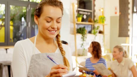 Beautiful-waitress-writing-order-in-notepad-4k