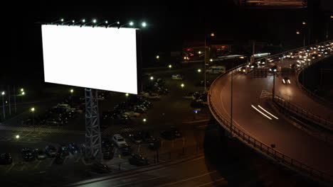 Zeitrafferaufnahme-Des-Nächtlichen-Autoverkehrs-In-Der-Stadt-Und-Eines-Leeren-Banners-Auf-Der-Straße