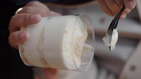 person eating layered dessert with a spoon