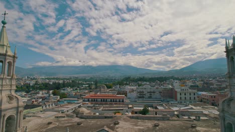 Reverse-aerial-drone-shot-revealing-Arequipa-Cathedral's-two-towers-and-the-cathedral-itself,-culminating-in-the-Plaza-de-Armas