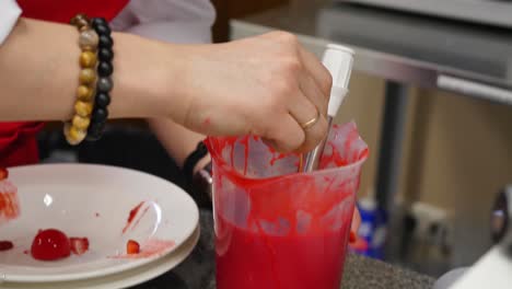 chef decorating dessert with red glaze