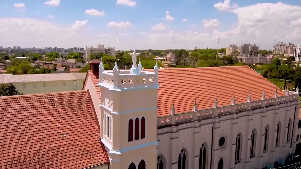 Le braccia distese di Cristo, incorniciate sullo sfondo di una grande chiesa