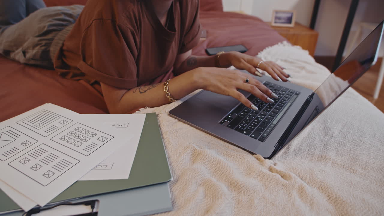 Female Freelancer Doing Annual Report on Laptop Lying on Bed