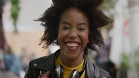 portrait-of-funky-african-american-woman-student-afro-laughing-cheerful-looking-at-camera-in-vibrant-urban-city-background