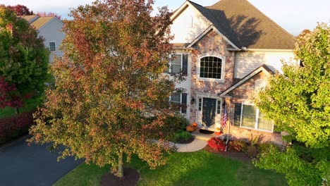 suburban home with fall foliage and american flag display