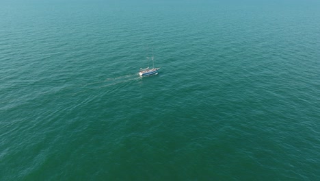 Luftaufnahme-Eines-Weißen-Segelboots-In-Der-Ruhigen-Ostsee,-Weiße-Segelyacht-Mitten-Im-Grenzenlosen-Meer,-Sonniger-Sommertag,-Weitwinkelaufnahme,-Die-Sich-Rückwärts-Bewegt