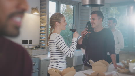 Group-Of-Multi-Cultural-Friends-Enjoying-Drinks-Party-With-Takeaway-Food-At-Home-Together