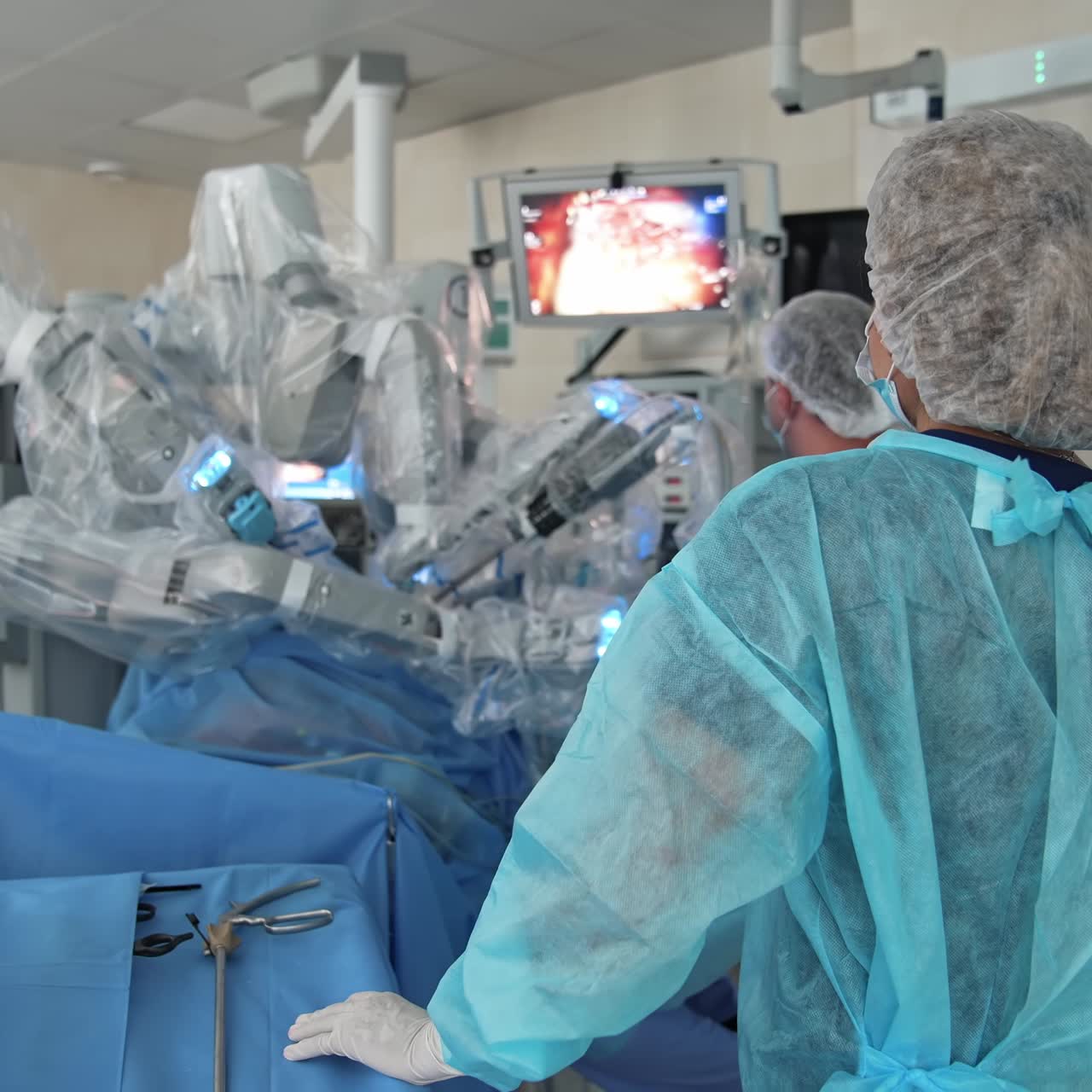 Surgical room with modern medical equipment. Minimally invasive surgery involving robot in operating room. Surgeons near robotic device in clinic