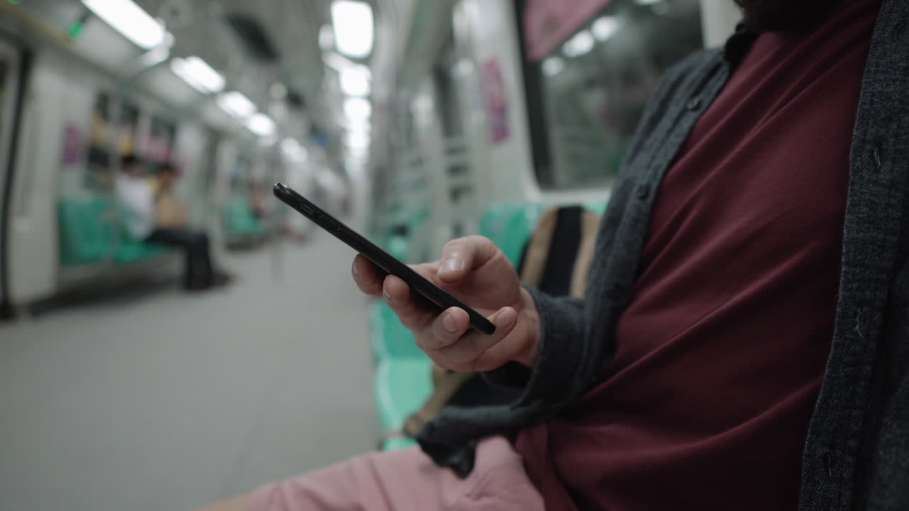 Man using smartphone on a subway