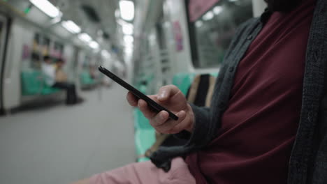 hombre usando un teléfono inteligente en un metro