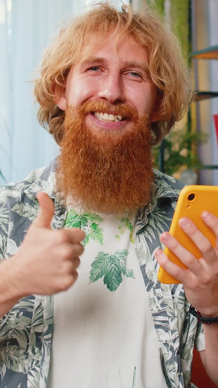 Giovane caucasico a casa usa lo smartphone celebra il successo vittoria vincente gioca a un gioco online