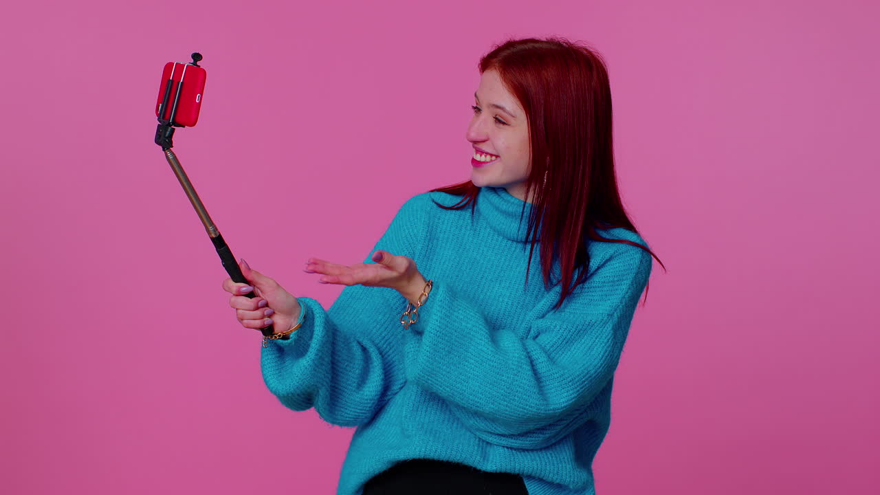 blogger adulta tomando selfies en el teléfono móvil, comunicándose en video llamada en línea con los suscriptores