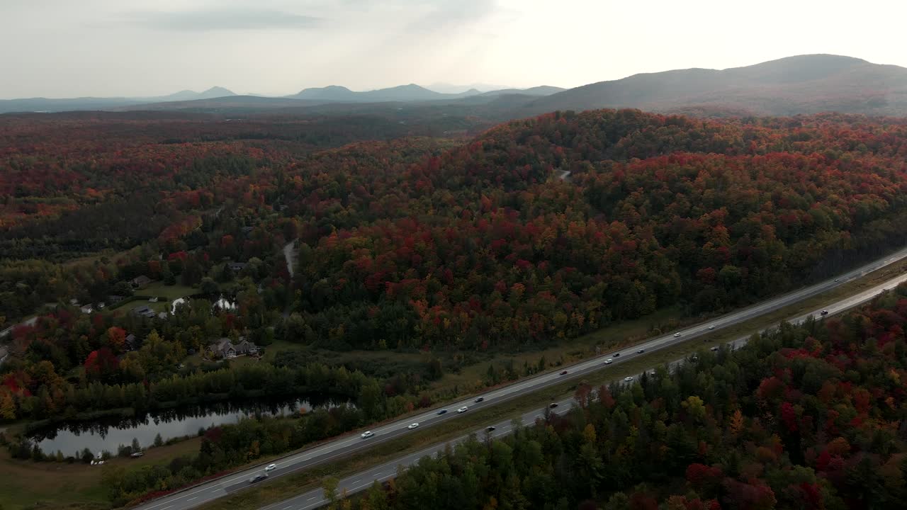 impresionante paisaje de otoño en las colinas a lo largo de la carretera con automóviles que viajan durante la mañana brumosa en los municipios del este, quebec, canadá