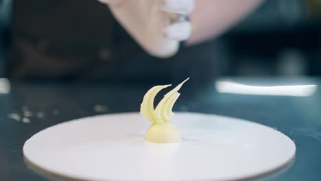 el confitero crea un pequeño elemento de chocolate blanco
