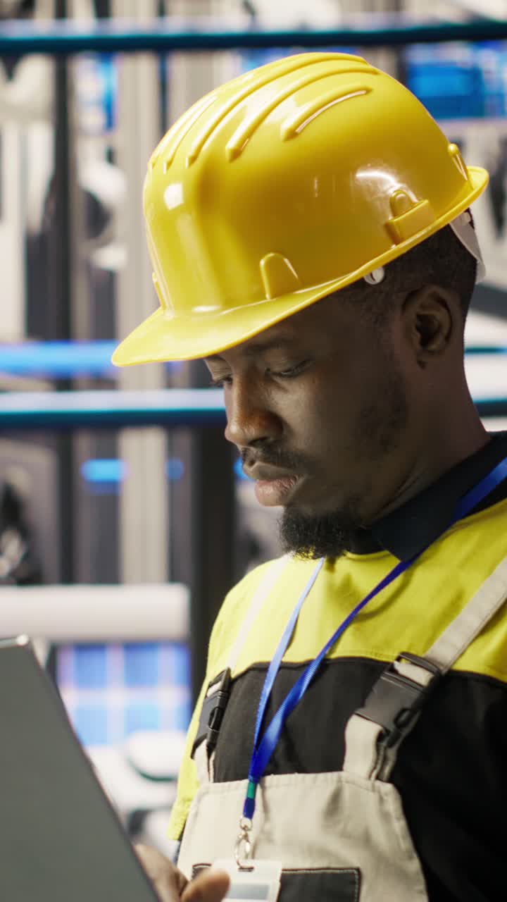 Vertical video Smart solar panels factory technician using laptop to oversee conveyor belts