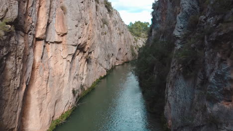 drohne fliegt über einen fluss zwischen felsigen bergen in valencia, spanien