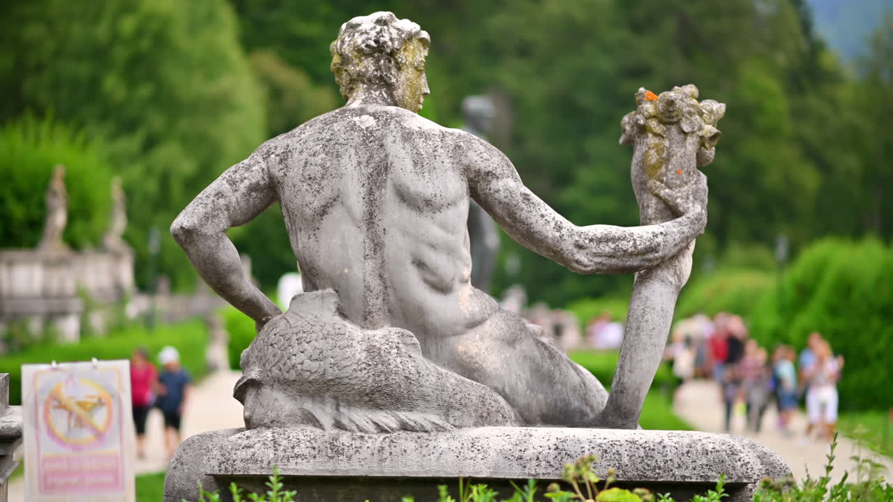 Statua al Castello di Peleș in Romania. Castello e persone sullo sfondo