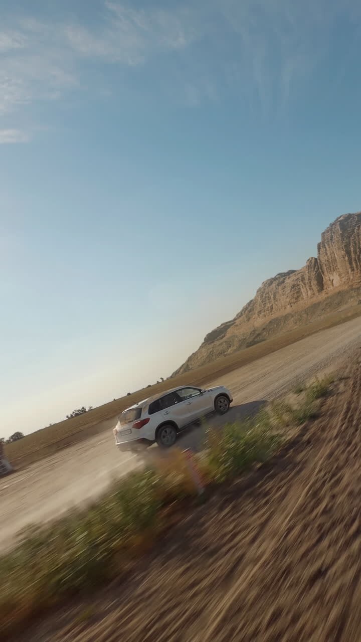 SUV Driving on a Dirt Road through a Scenic Landscape