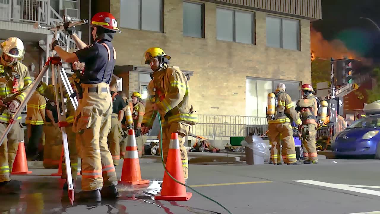 Firefighters ready equipment to spray water on building fire in Montreal, Quebec.