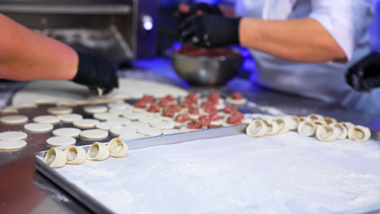 Factory workers making the dumplings with meat. Pelmeni with meat production at present day food enterprise.