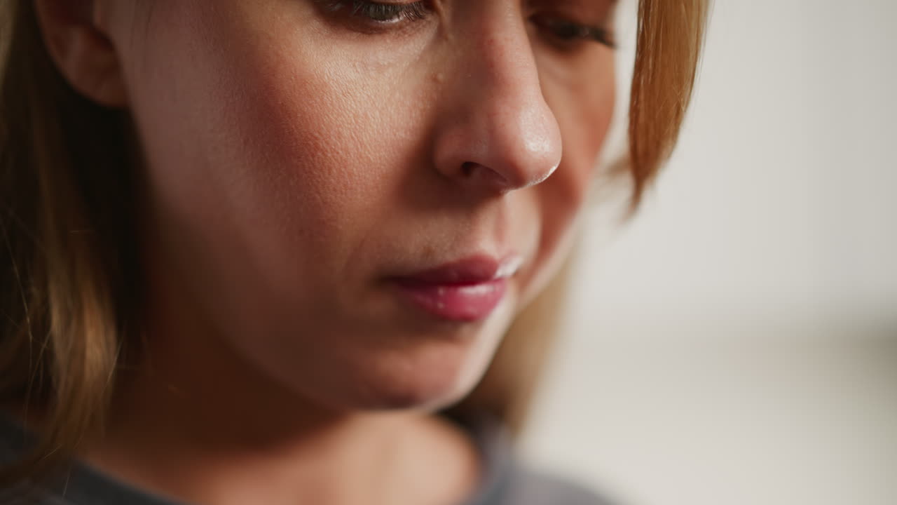 Extreme close up of girl eating breakfast with chopstick, soft indoor lighting highlights facial details, calm and focused expression as she looks downward