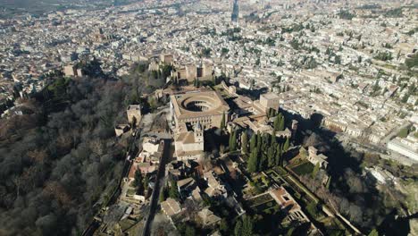 Dron-Dando-Vueltas-Pov-Del-Palacio-Charles-V-Dentro-De-La-Ciudadela-De-La-Alhambra-Con-El-Paisaje-Urbano-De-Fondo,-Granada-En-España