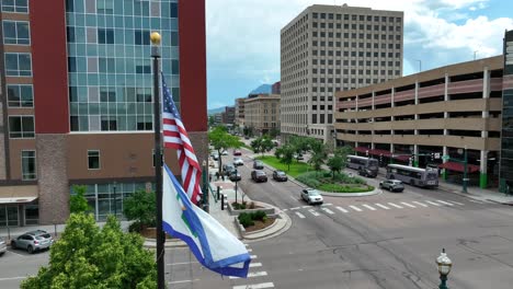 american and colorado springs flag waving in downtown