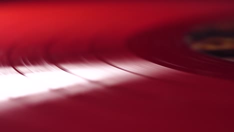 red vinyl record spinning on gramophone turntable, close up