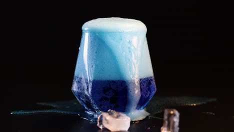 blue drink foaming and overflowing from glass