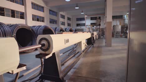 long black pvc pipes manufactured kept in rolls inside a pvc pipe making factory in karachi pakistan.