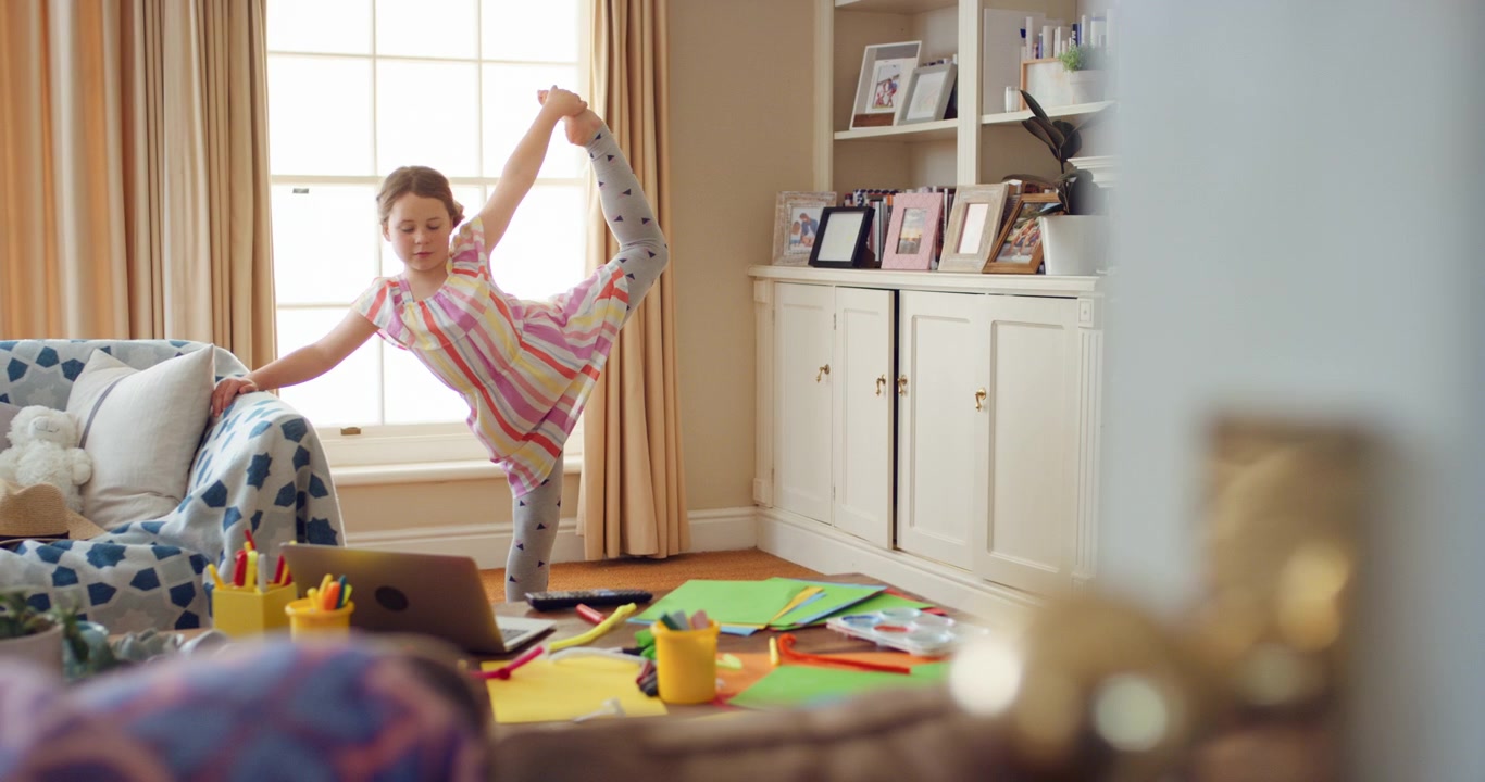 Young Girl Practicing Ballet Stretches at Home with Online Tutorial