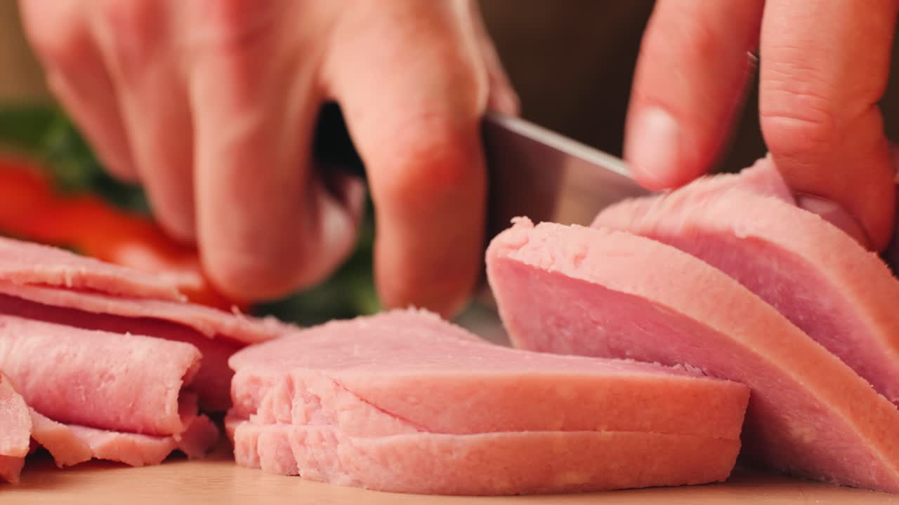 Ham italian mordatella, man Slices Of Traditional Italian antipasti mortadella sausage on a wooden cutting board, close up macro of chicken or turkey jamon, fat breakfast dish.