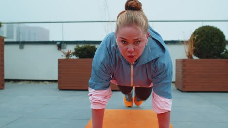 athletic sport girl doing running plank cross fitness bodybuilding training routine on rooftop