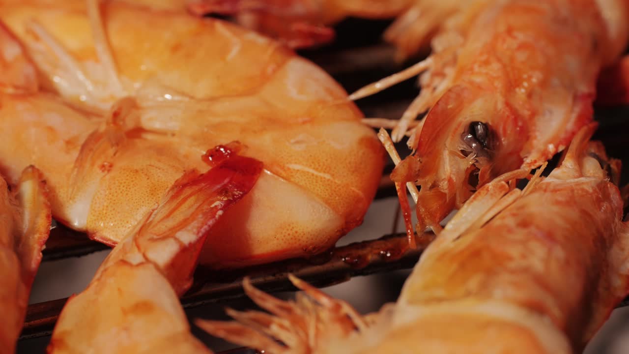 Chef cooking shrimps with oil and spices on grill close-up. Prawns on fire throwing them on pan. Restaurant Food concept. Sea food barbecue.