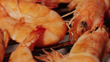 chef cooking shrimps with oil and spices on grill close-up. prawns on fire throwing them on pan. restaurant food concept. sea food barbecue.