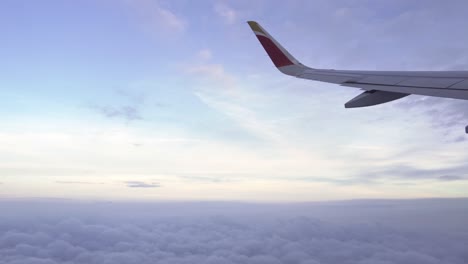 ala de avión volando sobre las nubes en una hermosa tarde ligera con nubes bajas