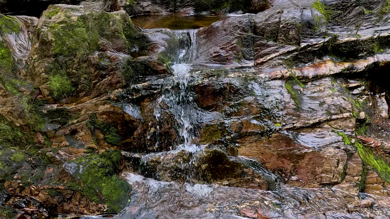 Flowing waterfall amidst lush greenery and rocks