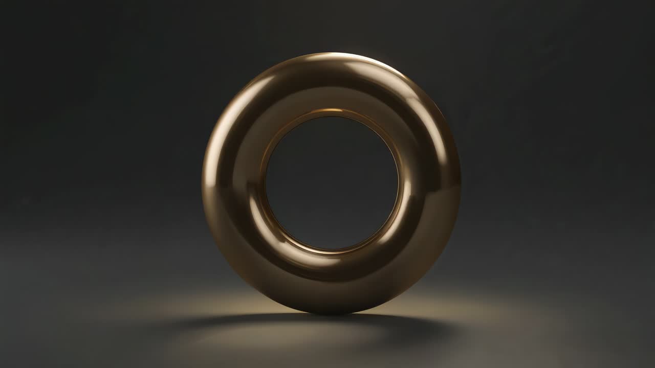 Animating polished golden torus rotating, revealing facets on gray studio floor with spotlight glow