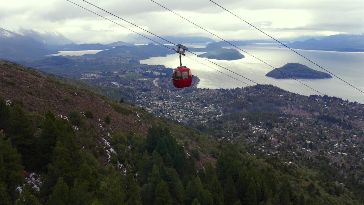 Funivia rossa sopra Bariloche che scende dal Cerro Otto con vista panoramica sul lago Nahuel Huapi e sulle isole.