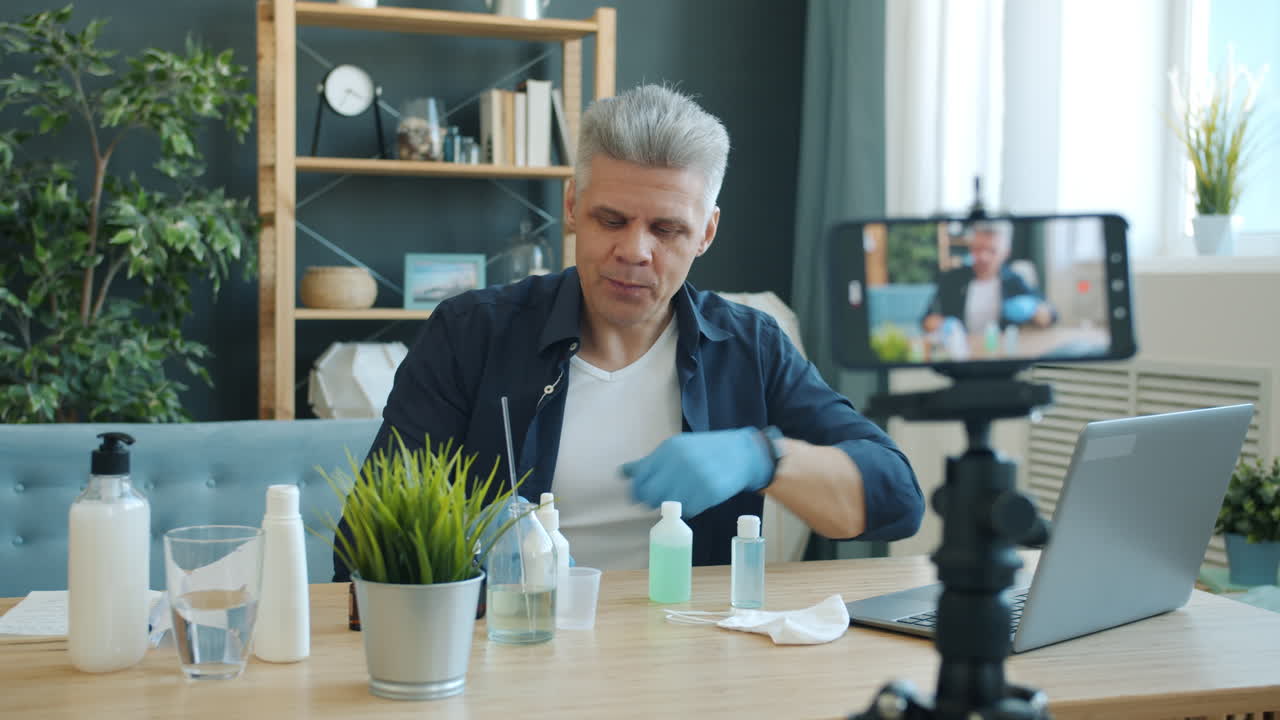 Man Demonstrating Hand Sanitizer and Disinfectant Products in Online Tutorial