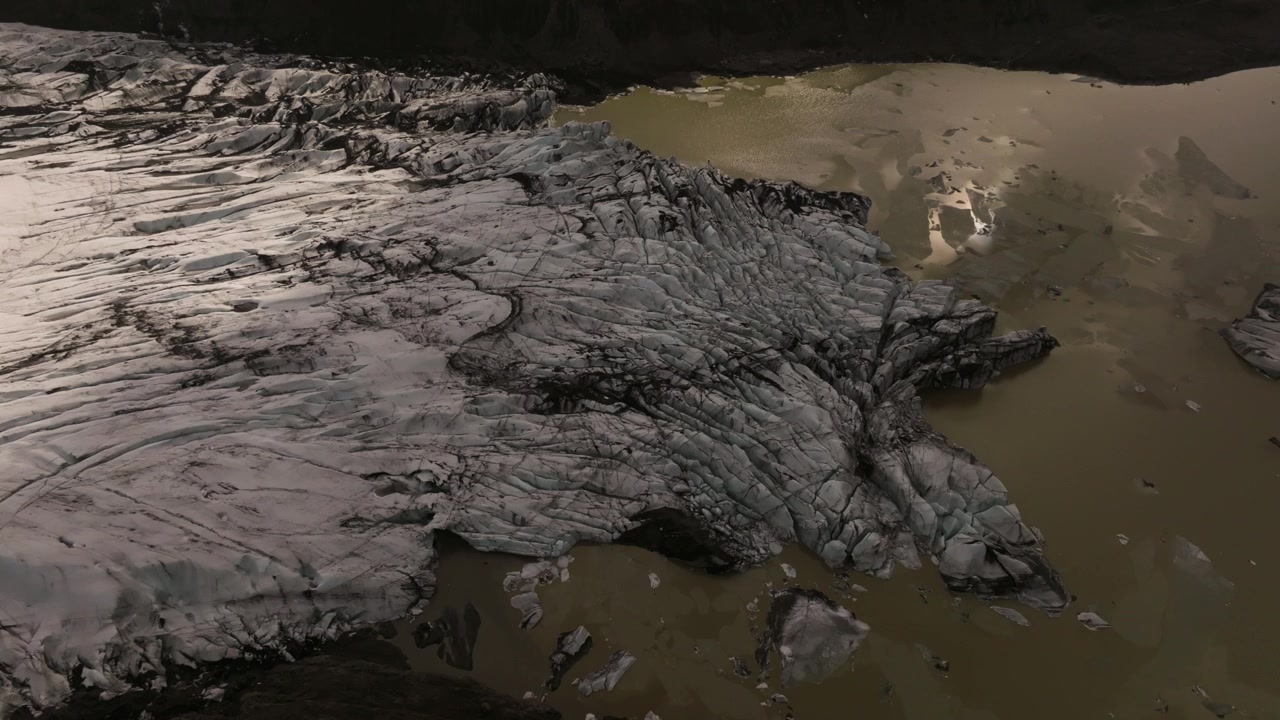 Ripresa aerea orbitale del ghiacciaio Sólheimajökul che si scioglie, coperto di morena, Islanda.