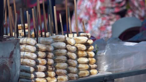 close exterior static shot of bananas on sticks on the street food stall in the day