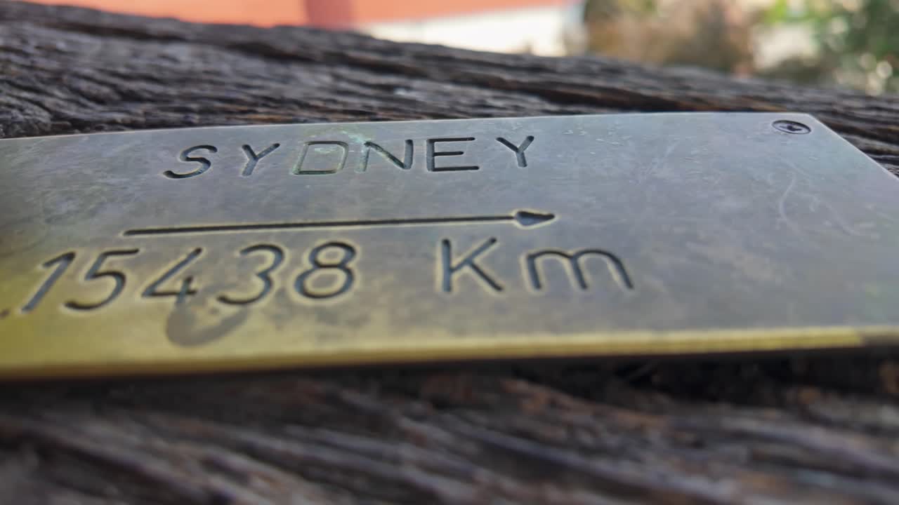 Close-up of a brass plate indicating the distance to Sydney, Australia from the Clock Tower in Sighișoara, Romania