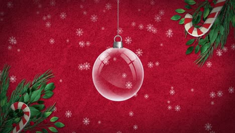 Animation-of-snow-falling-and-christmas-bauble-with-candy-canes-and-fir-tree-on-red-background